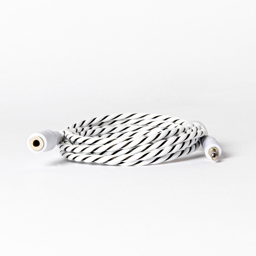 A white and black braided leak sensor cable coiled on a table